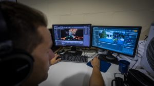 Prisoner facing two computer screens using design software.