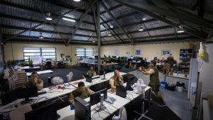 Prisoners in large training room working on computers.